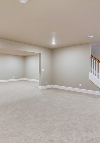 Light colored carpet with plenty of LED wafer lights to make this basement bright